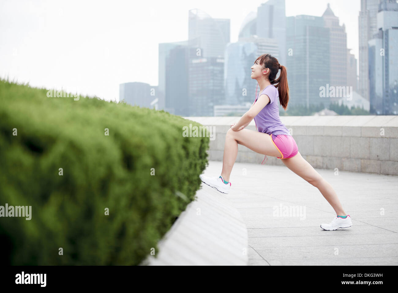 Female jogger stretching in Shanghai, Chine Banque D'Images