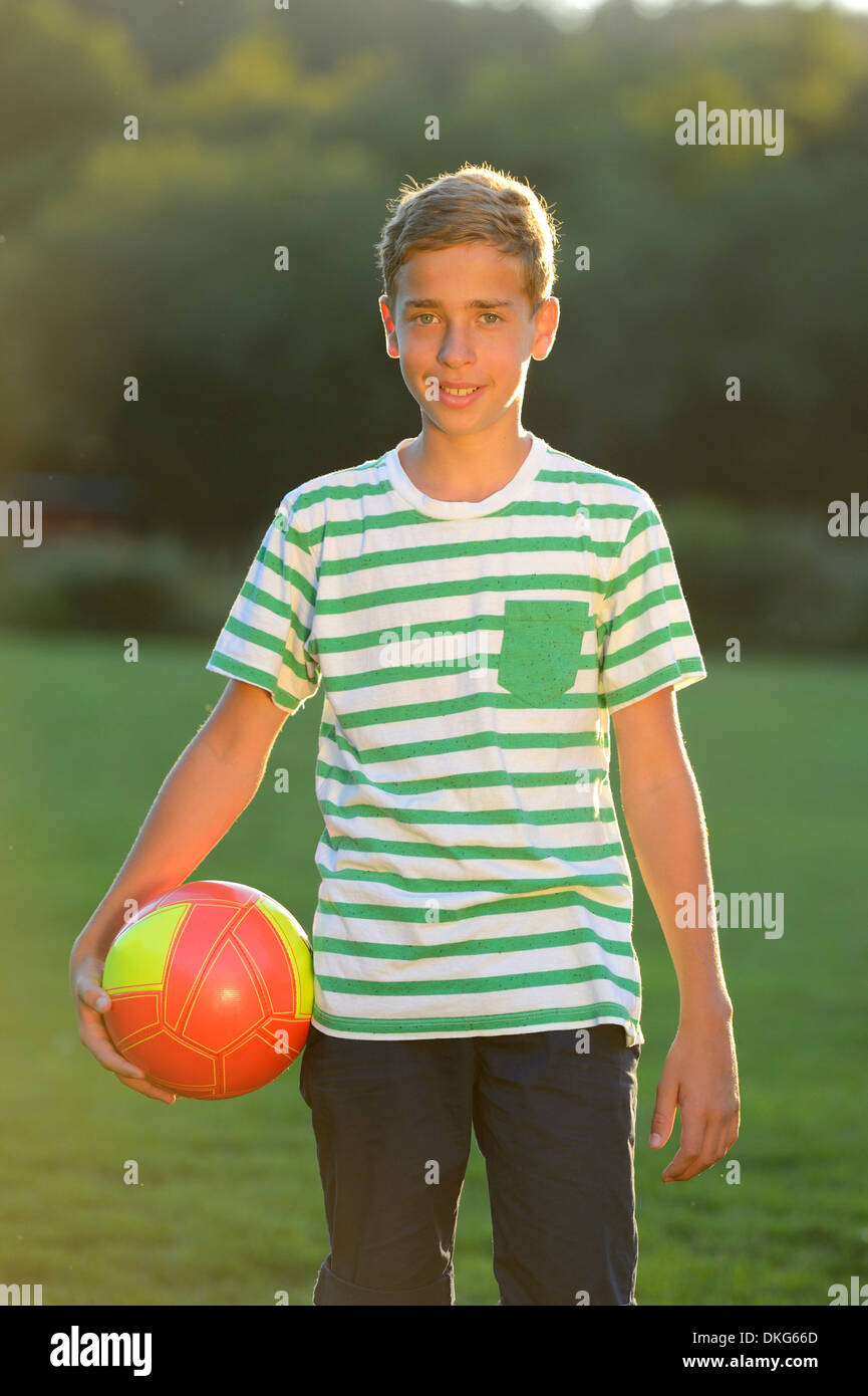 Teeange garçon debout avec le football sur pré, Haut-Palatinat, Bavaria, Germany, Europe Banque D'Images