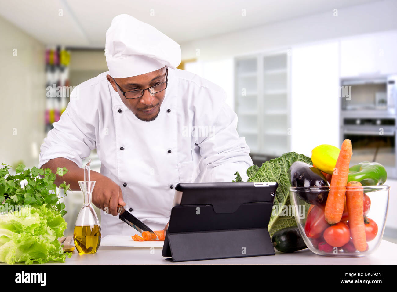 Male chef avec des fruits et légumes et les tablettes pour la recette Banque D'Images