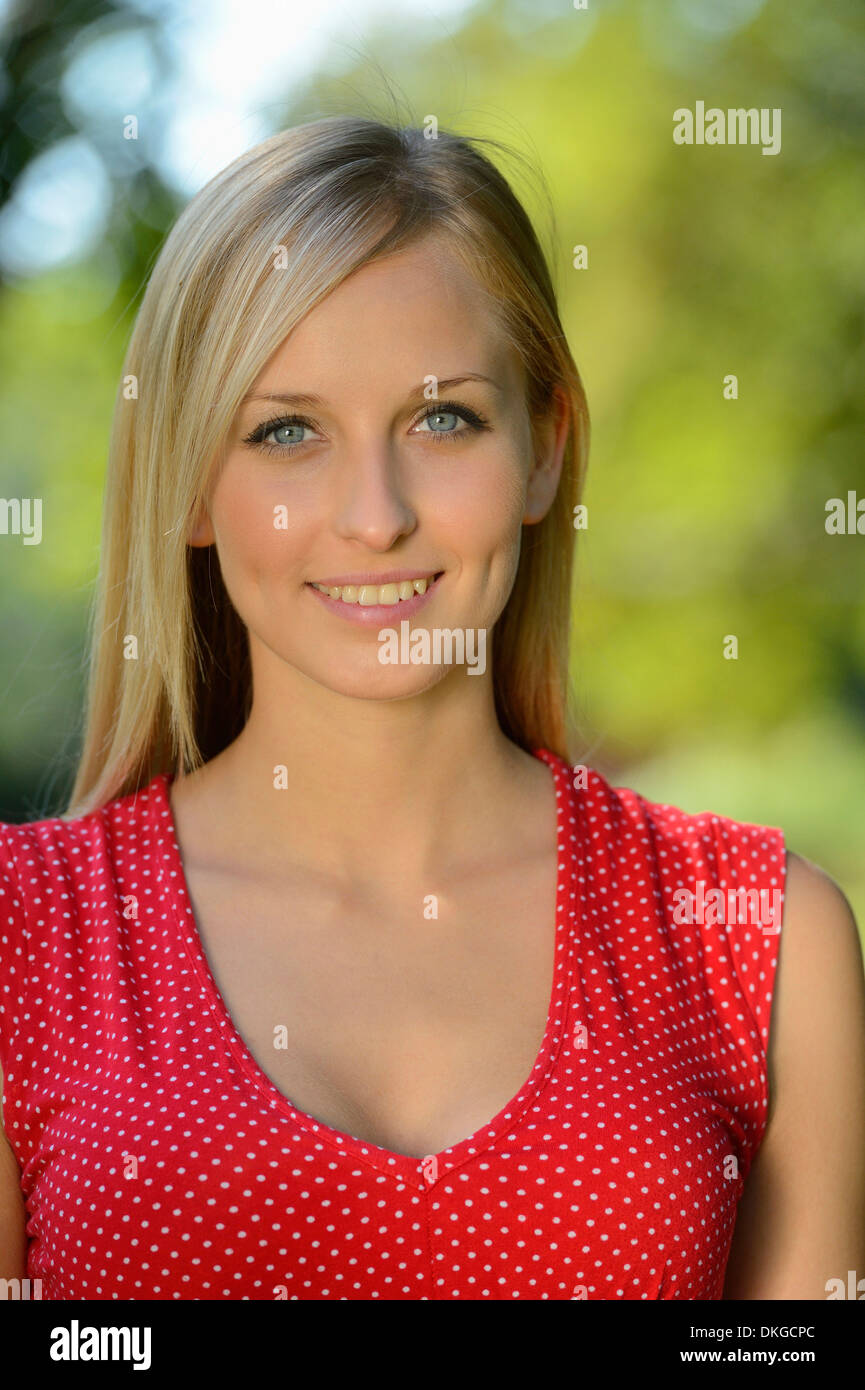 Smiling young blonde woman outdoors, portrait Banque D'Images