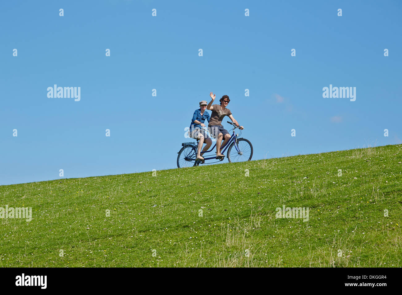 Deux cyclistes avec tandem sur digue, l'île de Pellworm, Allemagne Banque D'Images