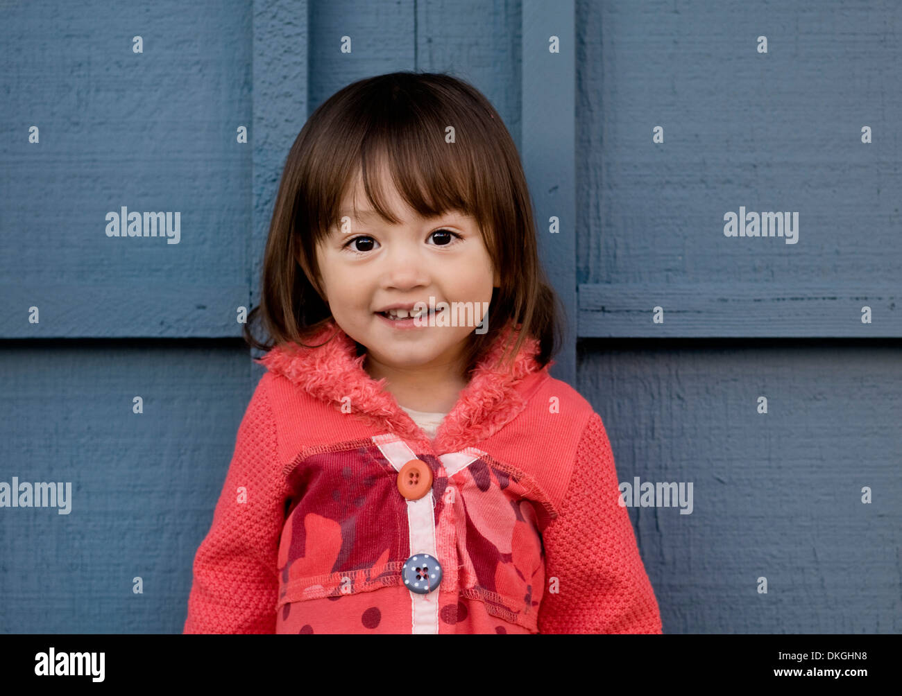 Un enfant de deux ans M. mixed race female sourit tout en ayant sa photo prise. Elle a les cheveux bruns, les yeux bruns Banque D'Images