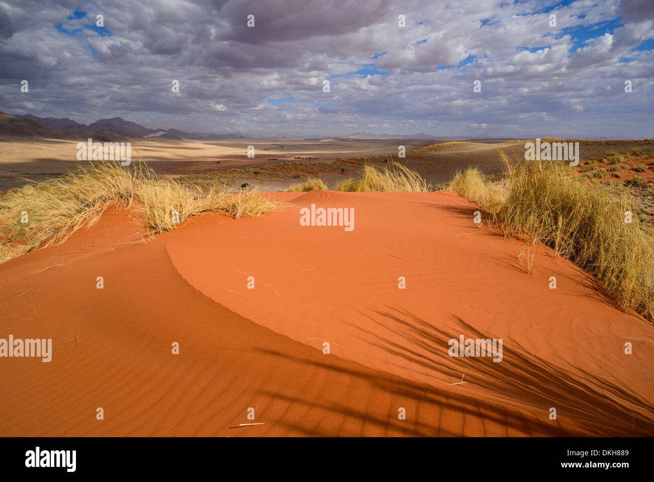 Les nuages au-dessus de la couvaison des dunes rouges de NamibRand, Désert du Namib, Namibie, Afrique Banque D'Images