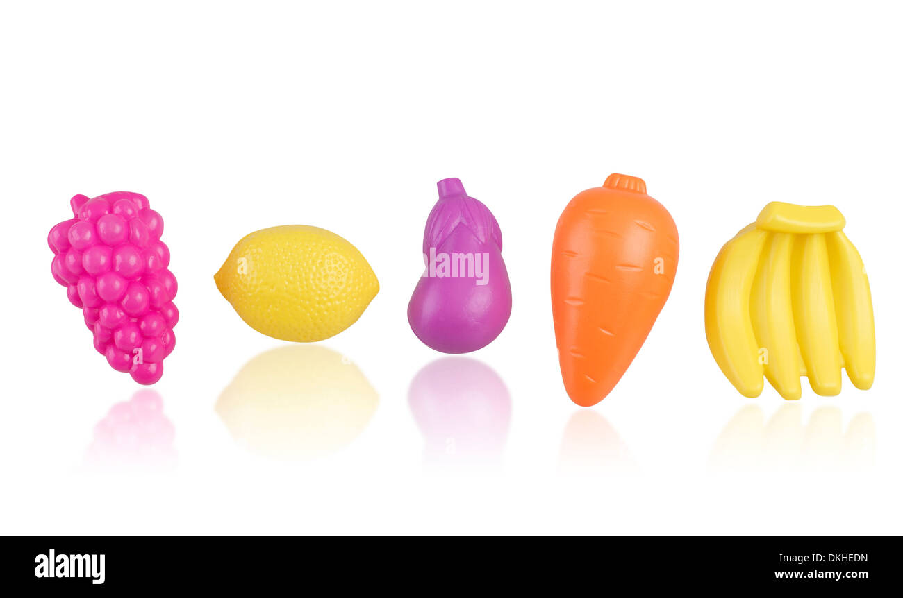 Les fruits, les légumes et les jouets en plastique isolé sur fond blanc Banque D'Images