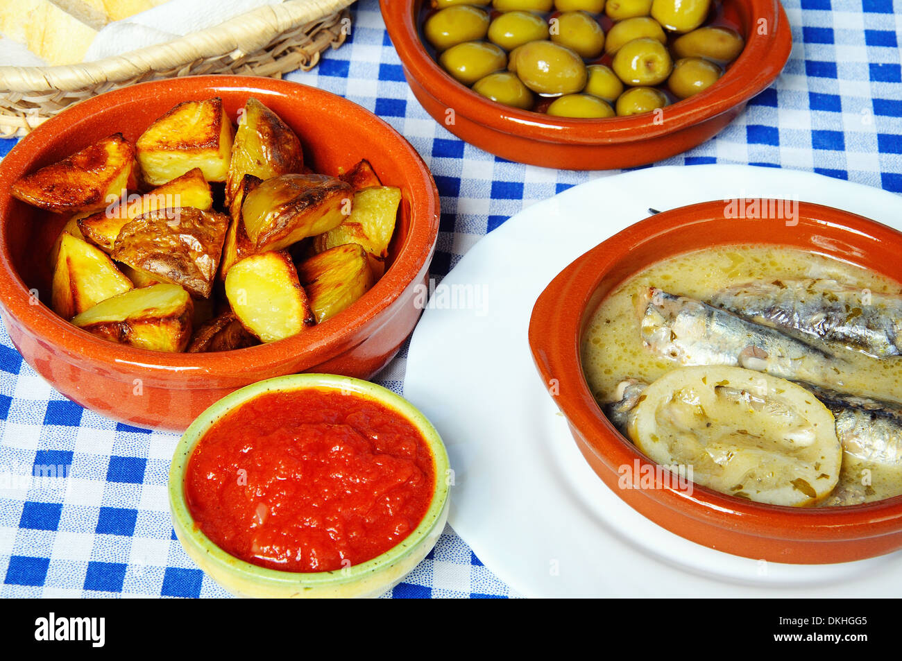 Sélection de Tapas - Sardines à la sauce citron vert , les olives et les pommes de terre dans une ébréchée sauce tomate épicée (patatas bravas). Banque D'Images