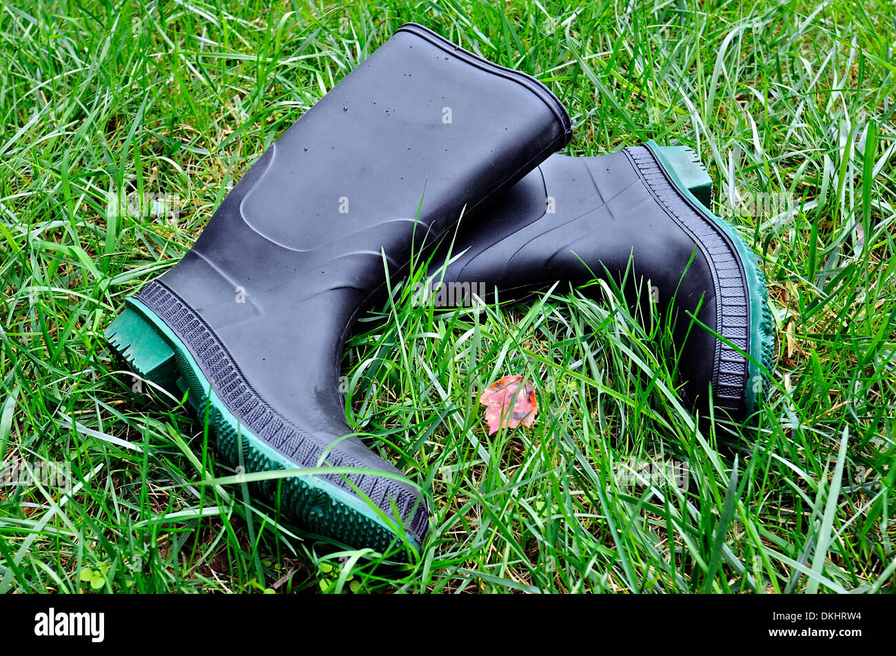 Une paire de bottes en caoutchouc dans l'herbe avec les petites gouttes de  pluie sur eux Photo Stock - Alamy