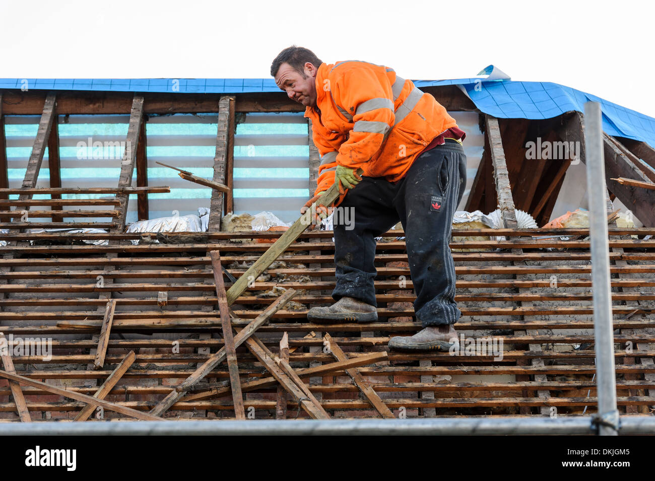 Un couvreur travaille sur un toit de bardeaux de cèdre, de remplacement en équilibre sur les pannes. Rénovation maison concept maison d'amélioration. Banque D'Images