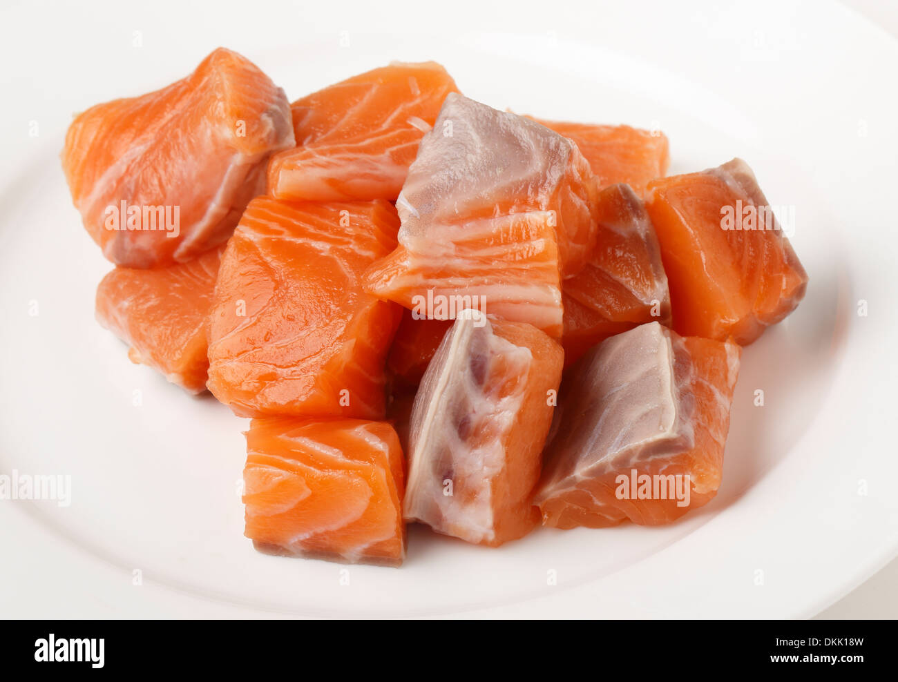 De mandrins, saumon frais coupé d'un filet, sur une assiette blanche en préparation pour la cuisson Banque D'Images