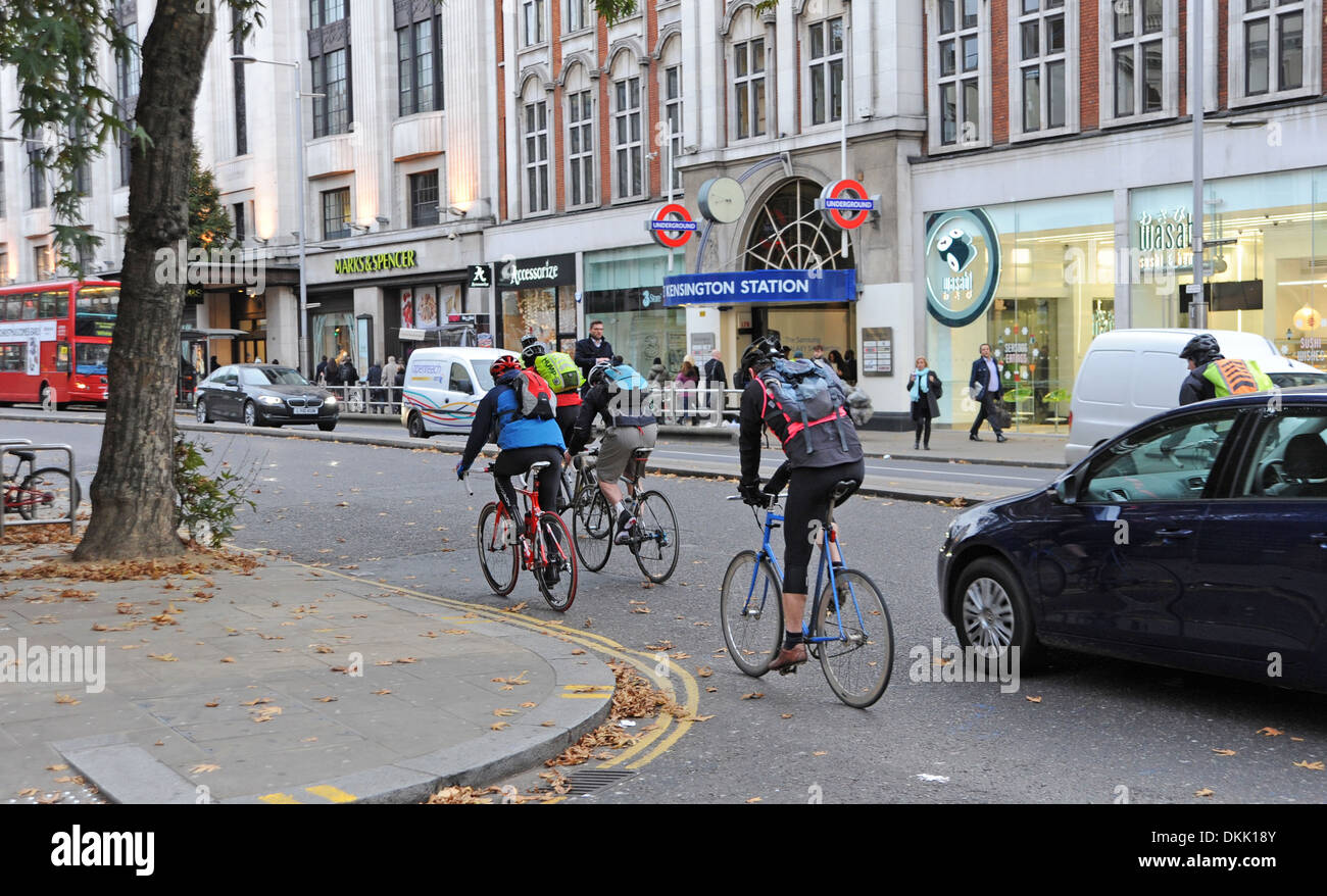 Les cyclistes négocier la circulation dans Kensington High Street Londres W8 UK Banque D'Images