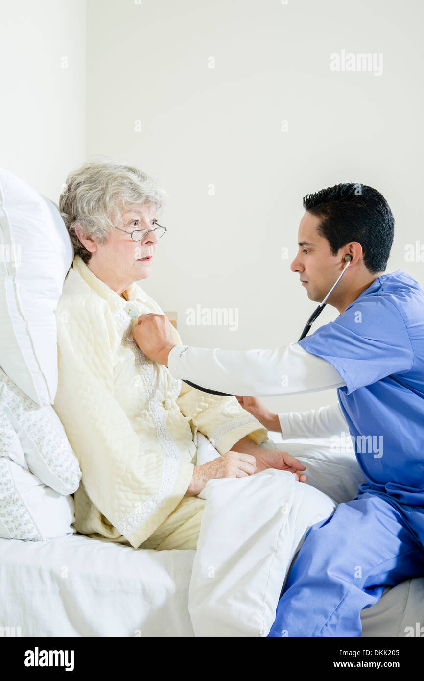 Infirmier l'écoute de la pulsation femme âgée Banque D'Images