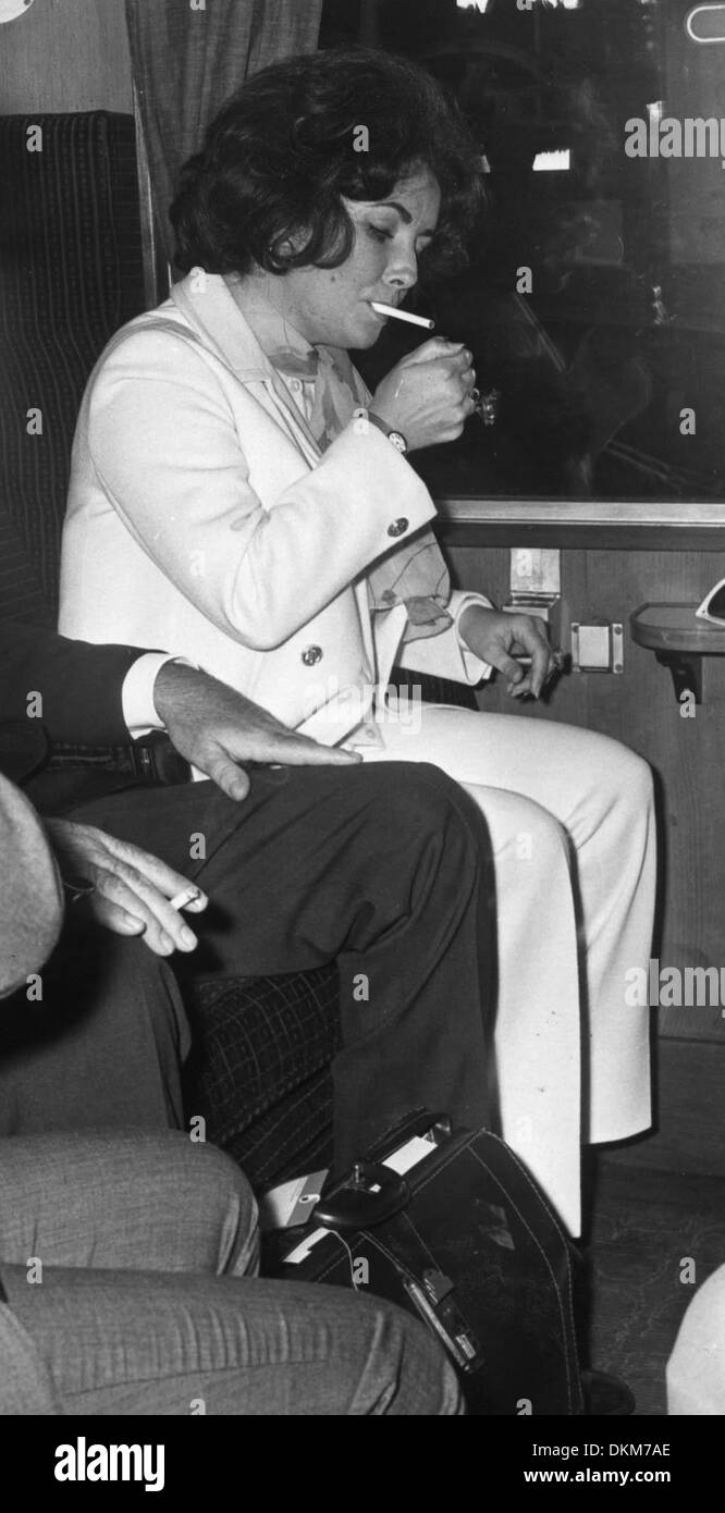 14 août 1968 - Londres, Angleterre, Royaume-Uni - l'actrice ELIZABETH 'Liz' TAYLOR (1932-2011) et son mari Richard Burton quittent la gare de Waterloo aujourd'hui. Sur la photo : Liz Taylor allume une cigarette avant que le train quitte la station. (Crédit Image : © Keystone Photos USA) Banque D'Images