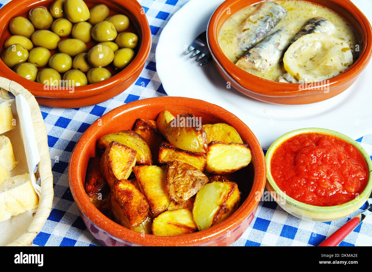 Sélection de Tapas - Sardines à la sauce citron vert , les olives et les pommes de terre dans une pierre taillée de la sauce tomate épicée, Espagne. Banque D'Images