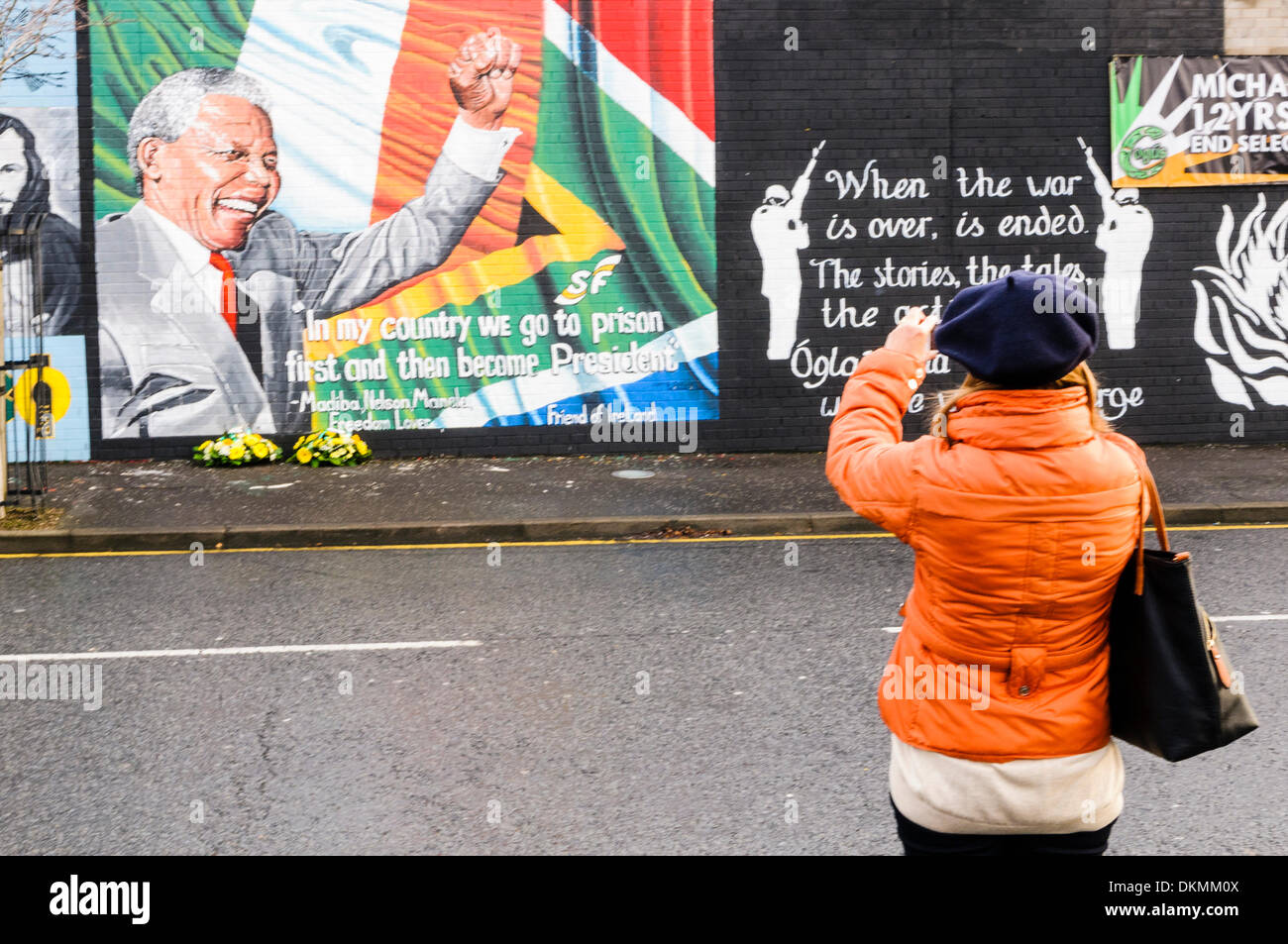 Belfast, Irlande du Nord. 7 décembre 2013 - Une femme prend une photo de la peinture murale à l'aide de Nelson Mandela un iPhone. Crédit : Stephen Barnes/Alamy Live News Banque D'Images