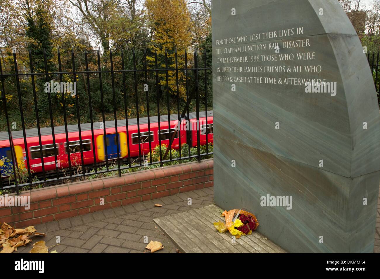 Clapham Junction, Londres, Royaume-Uni. 5 déc, 2013. Fleurs jetées lors de la catastrophe ferroviaire de Clapham Junction memorial marquer le 25e anniversaire de l'accident survenu le 13 décembre comme un train s'engouffre par. 35 personnes ont été tuées et 100 autres blessées après 3 trains sont entrés en collision au cours de la matinée : Crédit photographique à vue/Alamy Live News Banque D'Images