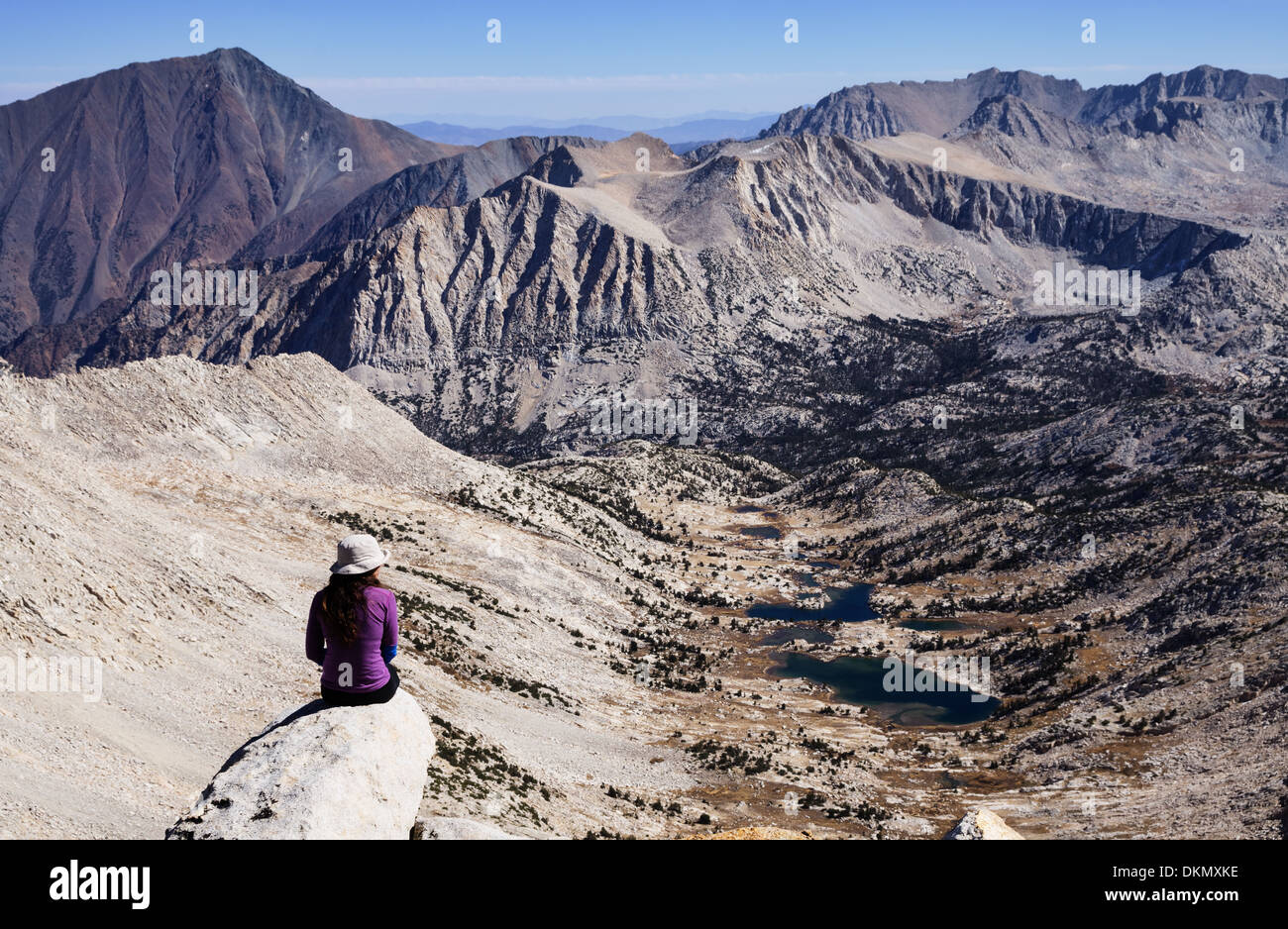 Femme assise au sommet d'une montagne dans la Sierra Nevada à la vue sur la montagne Banque D'Images