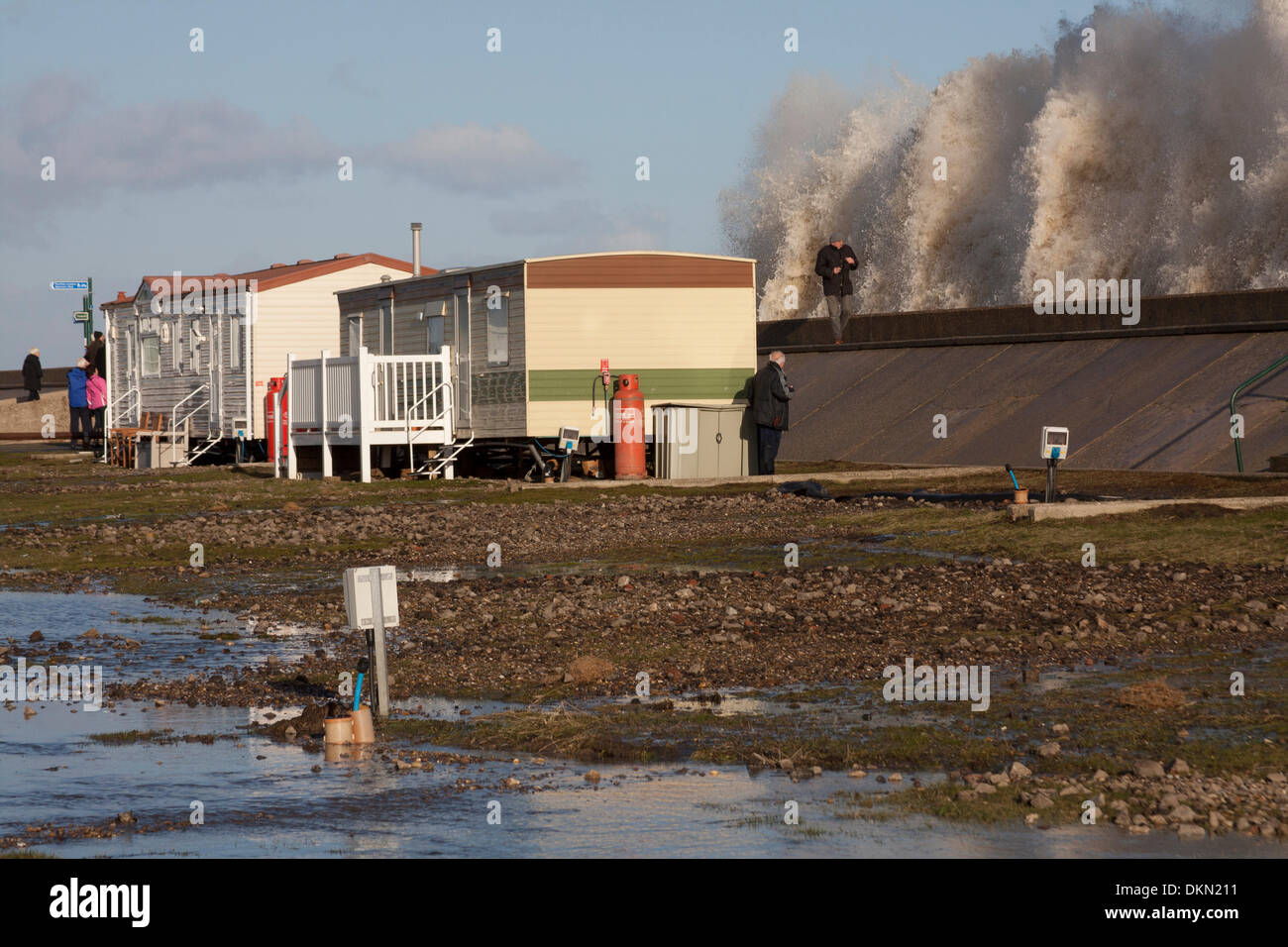 Lowestoft, UK. 06 Dec, 2013. Spectateurs watch vagues sur un raz-de-marée se briser sur la digue à Lowestoft derrière North Deanes Caravan Park, le vendredi 6 décembre 2013. Une combinaison de la marée haute et la marée pire dans 60 ans a été causant des inondations et l'évacuation à travers l'Est de l'Angleterre - Lowestoft est point le plus à l'Est de l'UK Crédit : Solveig Stibbe/Alamy Live News Banque D'Images