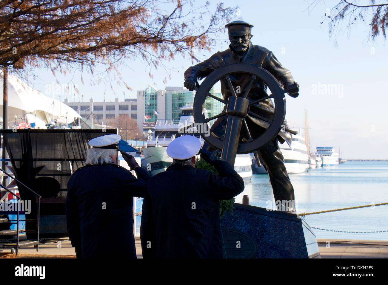 Chicago, Illinois, USA. 7 décembre 2013. Deux membres de l'Association International Shipmasters saluer après avoir placé une couronne au capitaine sur la tête' statue au Navy Pier à l'assemblée annuelle de l'arbre de Noël cérémonie du navire. L'événement est à la mémoire de la goélette Rouse Simmons, l'arbre de Noël d'origine des navires, qui a été perdu avec toutes les mains au cours d'une tempête le 23 novembre 1912. Credit : Todd Bannor/Alamy Live News Banque D'Images