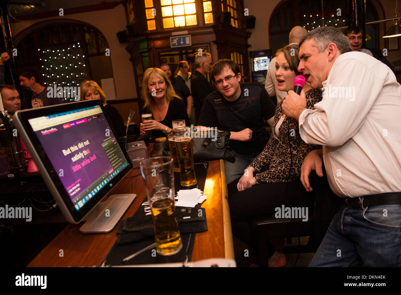 Un groupe de personnes chantant des amis à une machine à karaoké dans le château hôtel pub bar Aberystwyth UK Banque D'Images