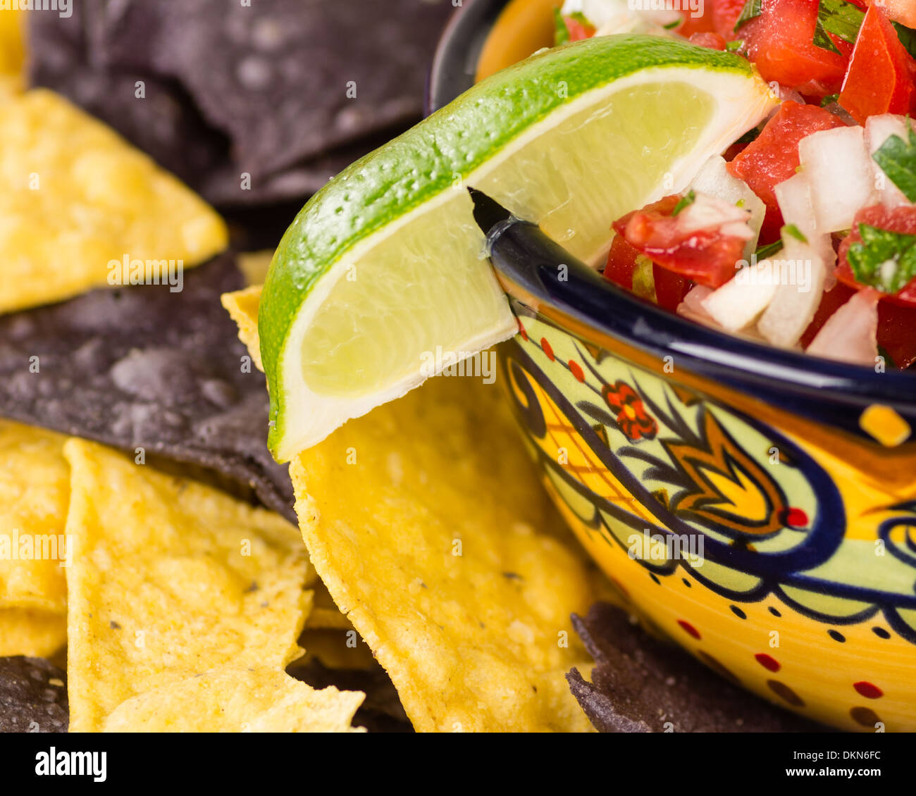 Un bol de fantaisie avec nacho chips de maïs et oignon frais salsa de tomates Banque D'Images