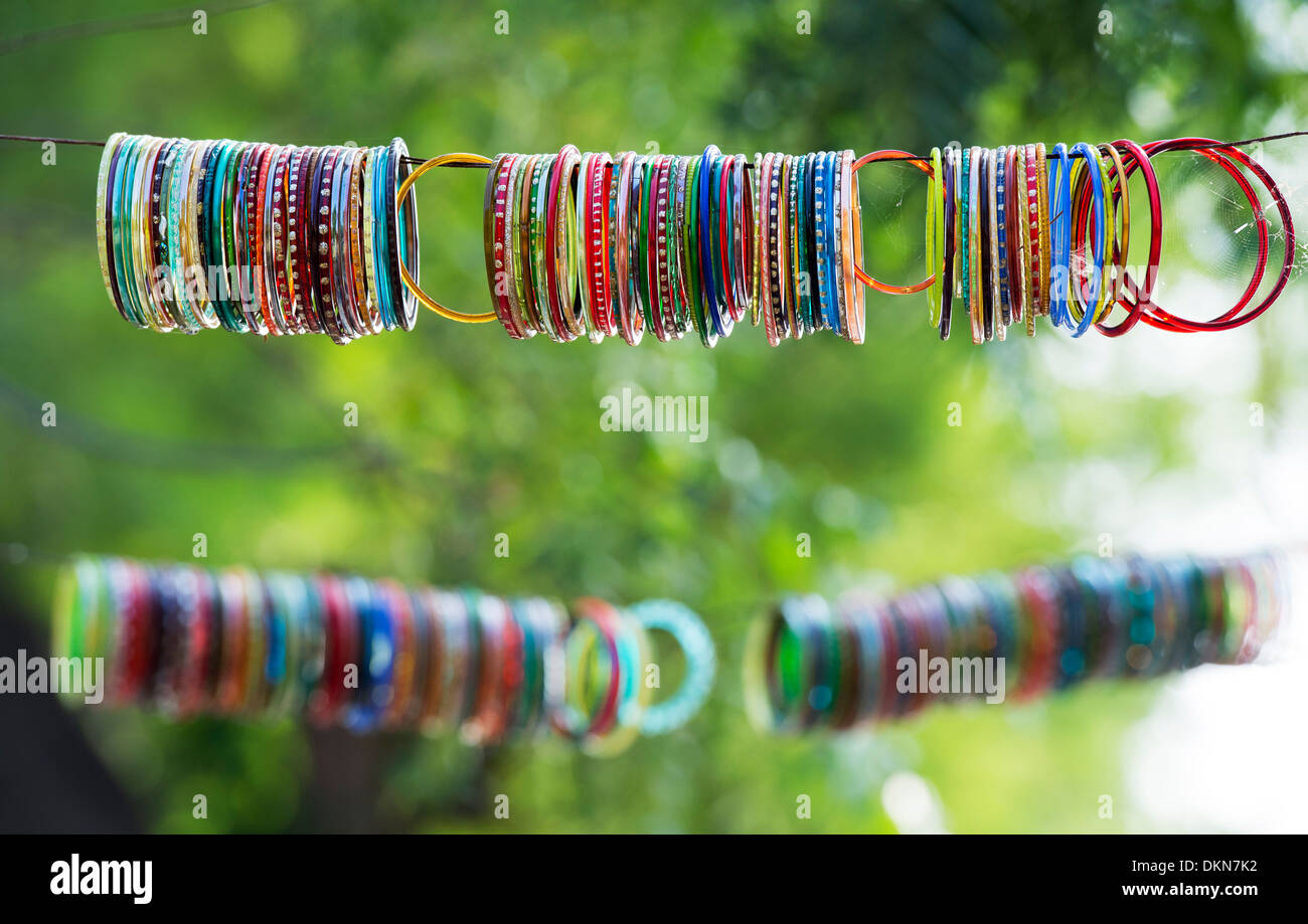 Les femmes indiennes colorés bracelets accrochés sur une ligne en face d'un temple hindou pour la décoration. L'Andhra Pradesh, Inde Banque D'Images