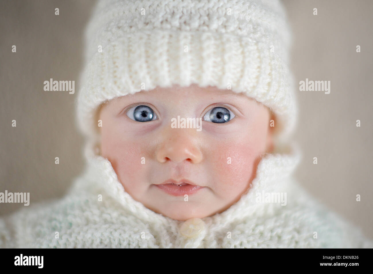 Bébé avec les yeux bleus en blanc hiver hat Banque D'Images