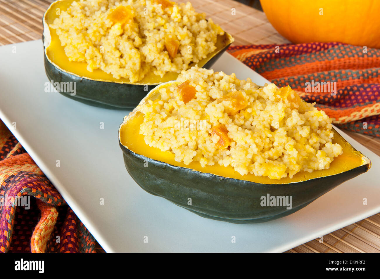 Courge poivrée farcie aux abricots et de couscous sur une plaque blanche Banque D'Images