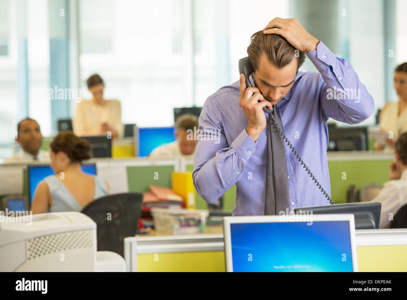 Businessman talking on telephone in office Banque D'Images