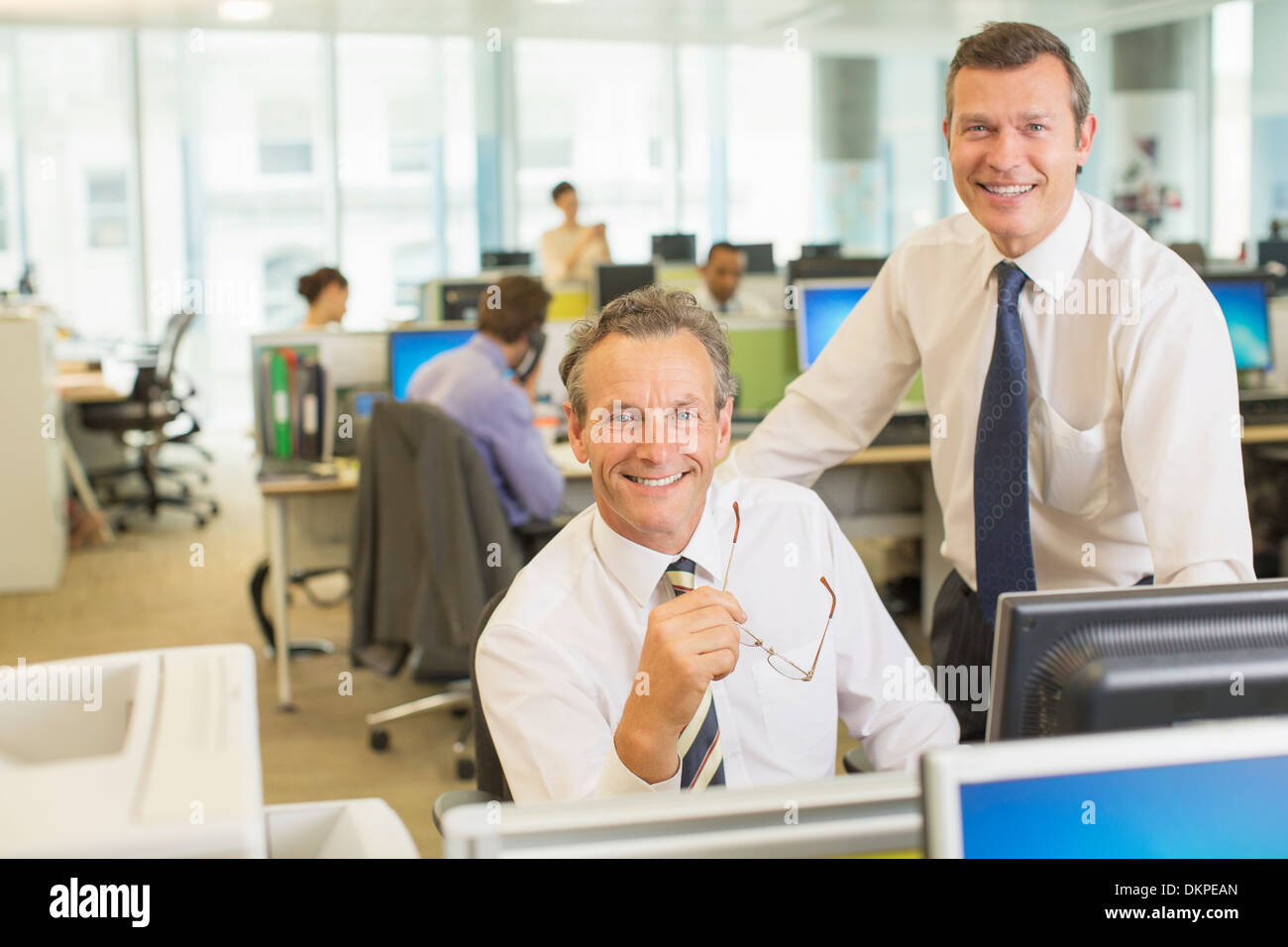 Businessmen smiling in office Banque D'Images
