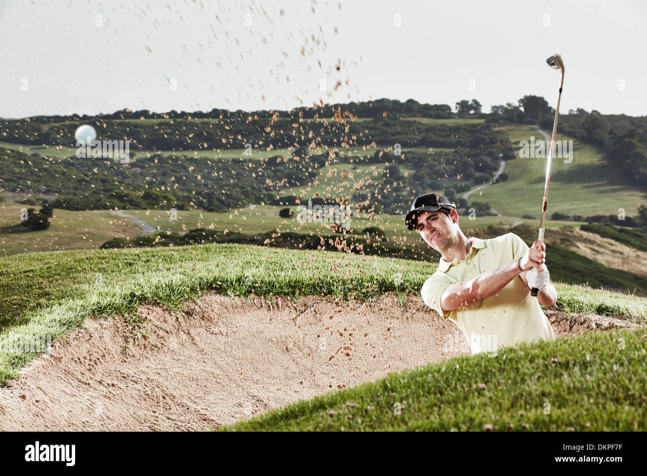 L'homme se balançant de sand trap on golf course Banque D'Images