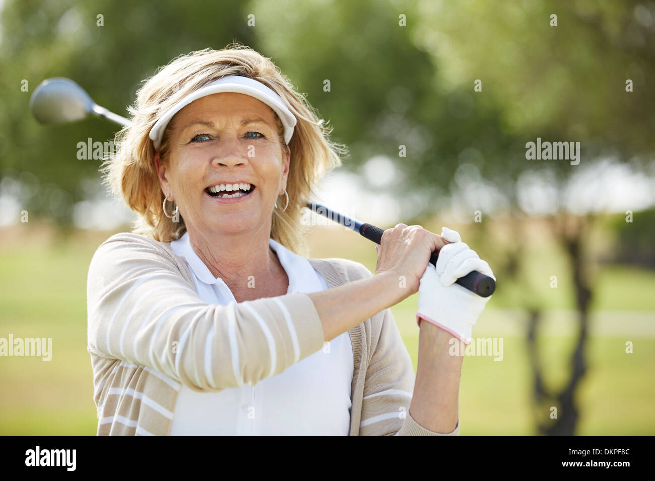 Senior woman playing golf on course Banque D'Images
