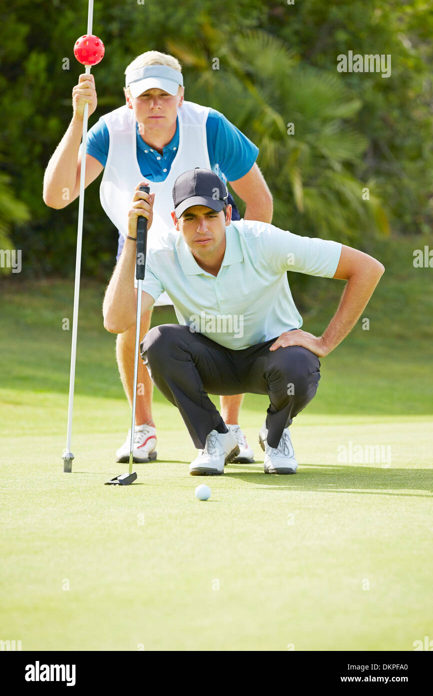 Caddy et golfeur sur putting green Banque D'Images