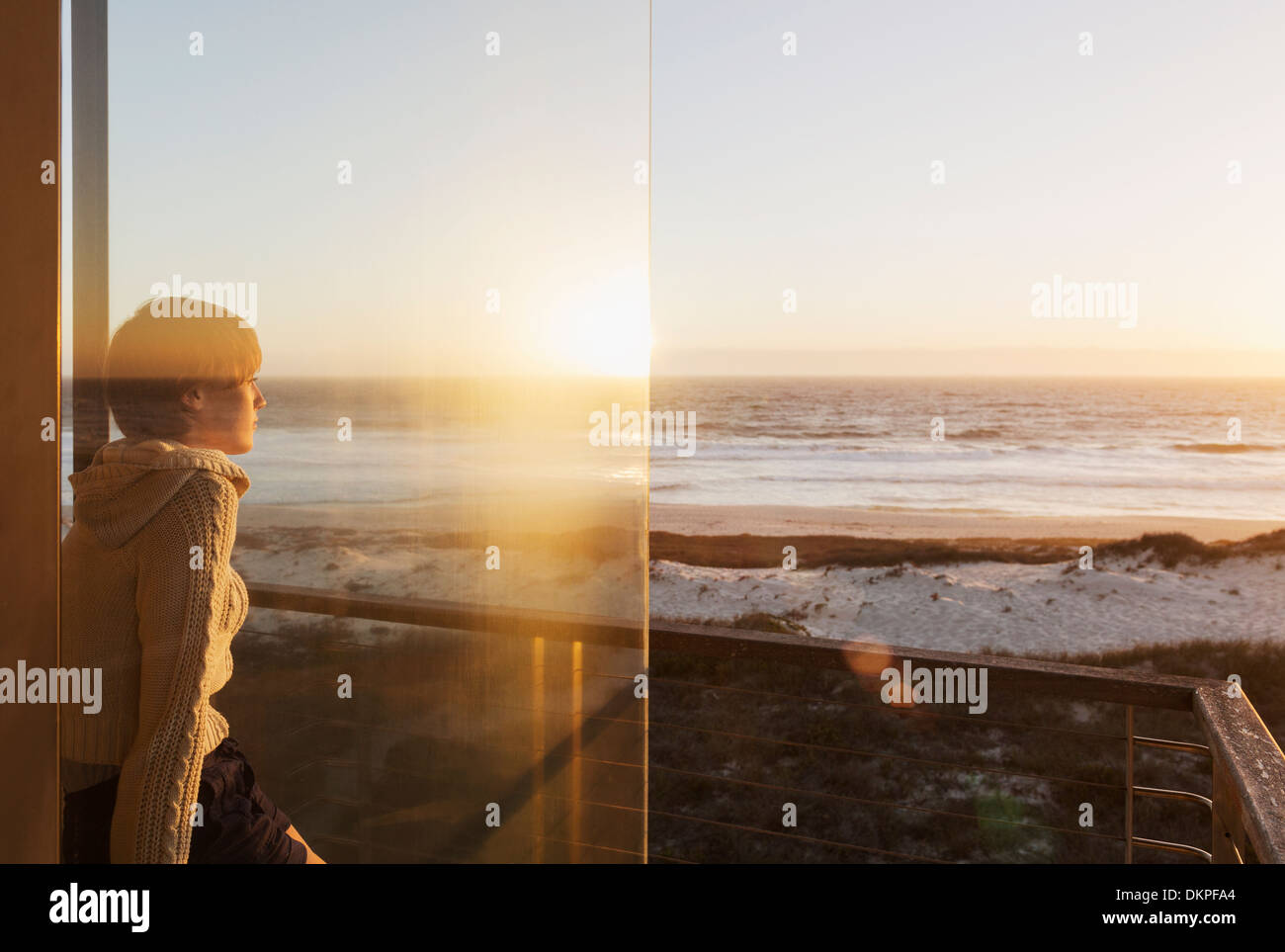 Femme regardant le coucher du soleil sur l'océan Banque D'Images
