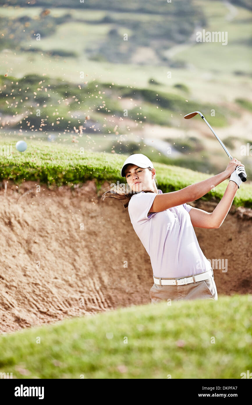 Femme balançant d'fosse de sable on golf course Banque D'Images