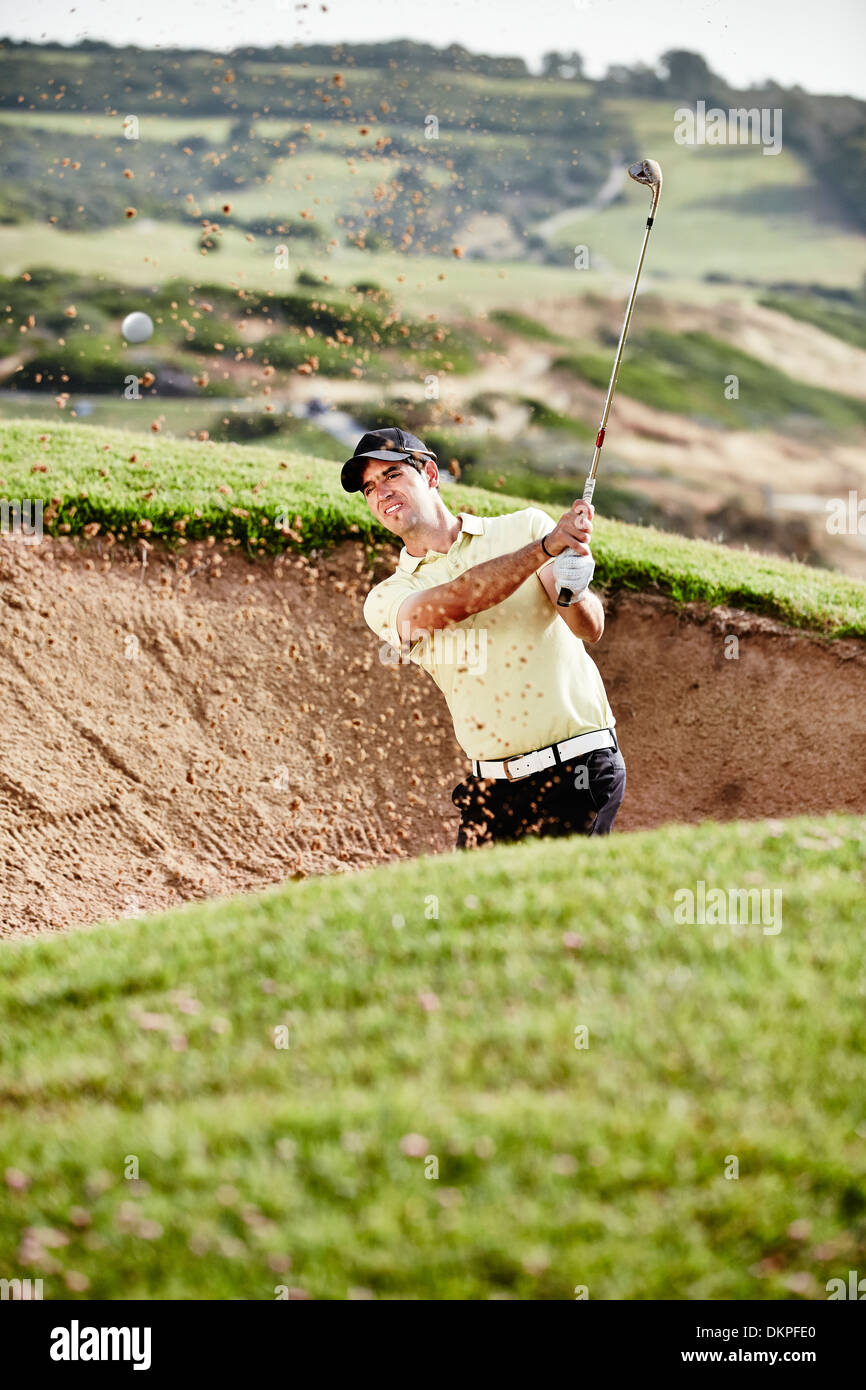 L'homme se balançant de sand trap on golf course Banque D'Images