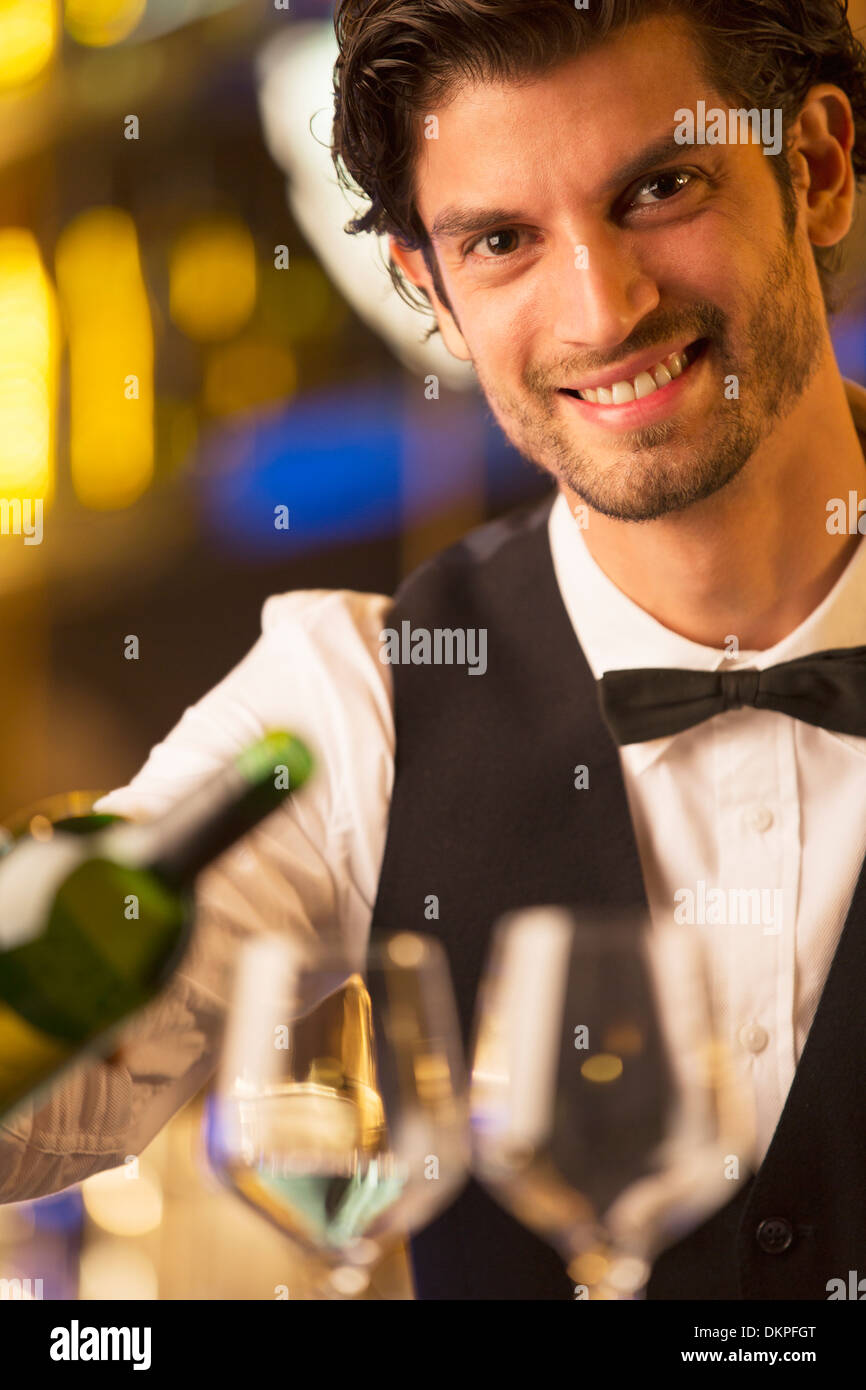 Close up portrait of well dressed bartender pouring wine Banque D'Images