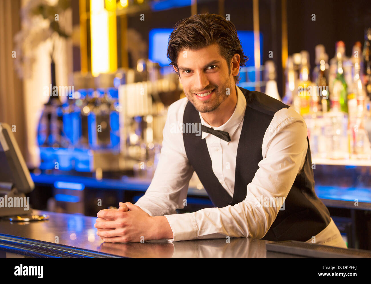 Portrait de barman bien habillé s'appuyant sur bar Banque D'Images