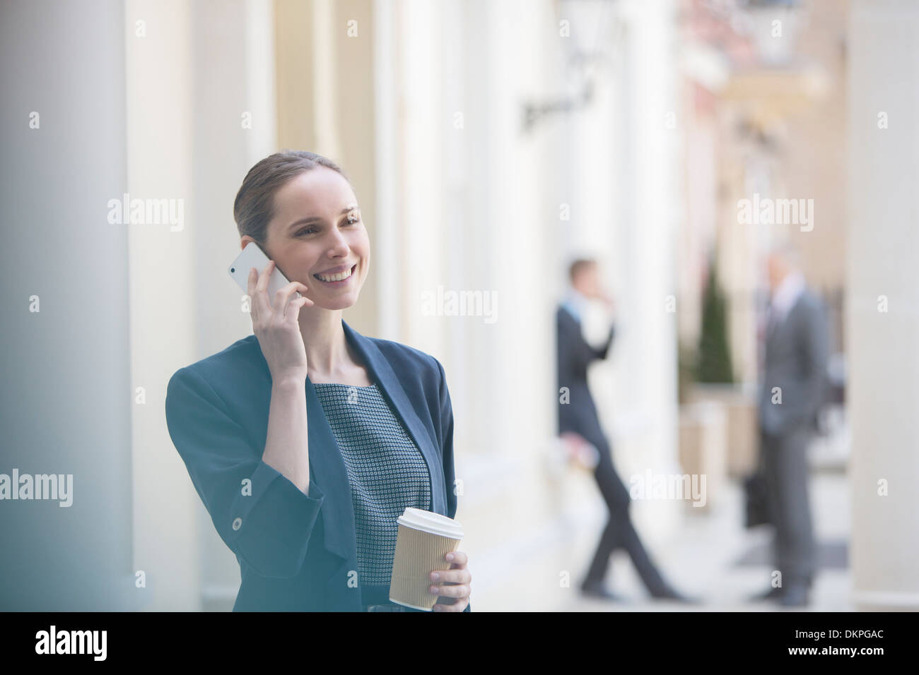 Businesswoman talking on cell phone on city street Banque D'Images