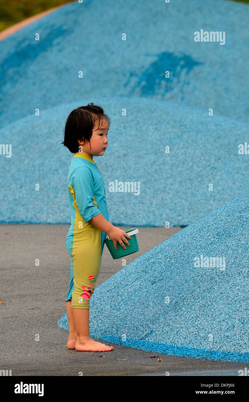 Chinese girl enfant joue avec de l'eau à Singapour park Banque D'Images