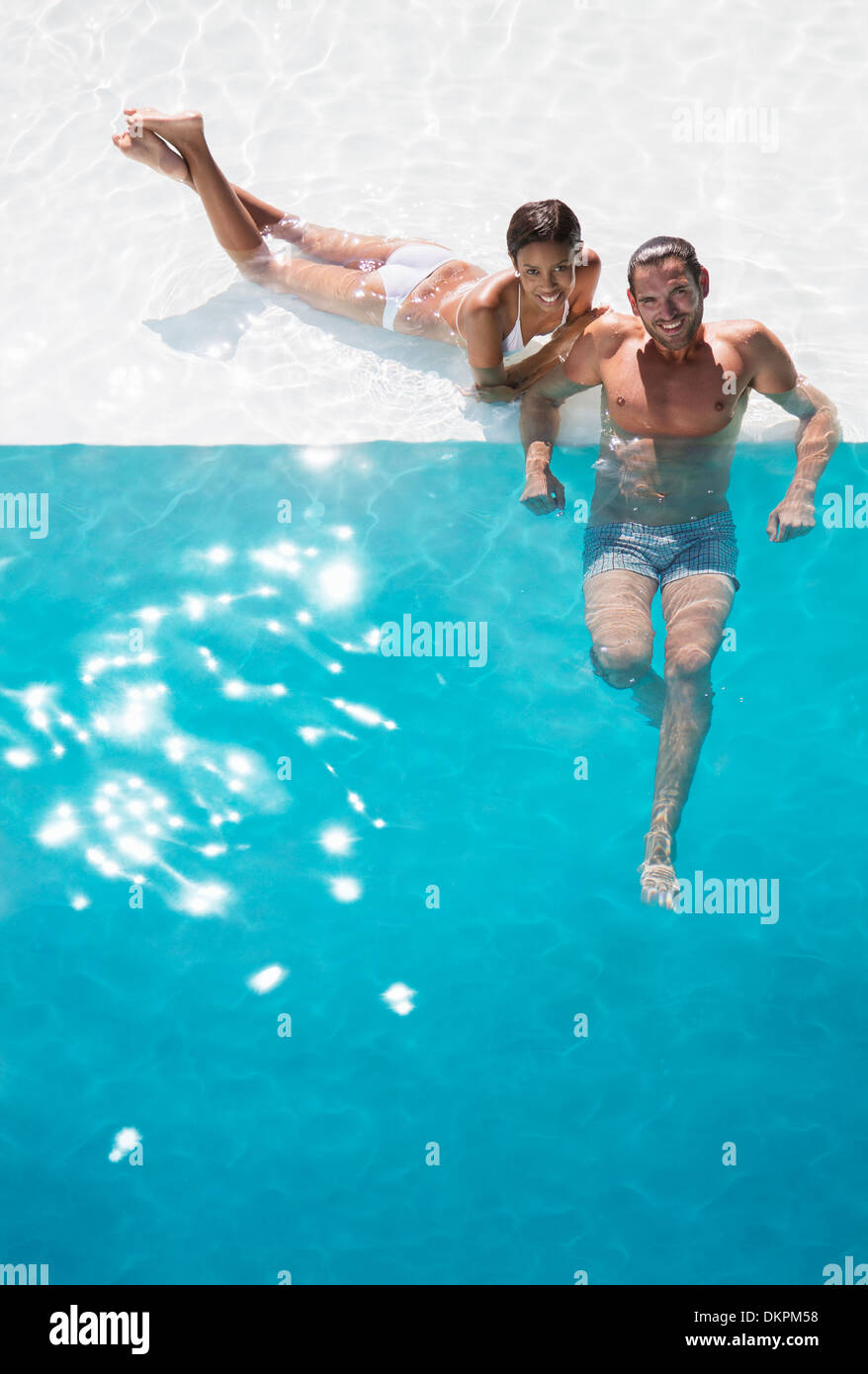 Portrait of smiling couple relaxing in swimming pool Banque D'Images