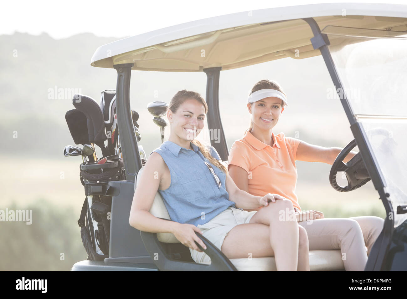 Les femmes au volant sur chariot de golf course Banque D'Images