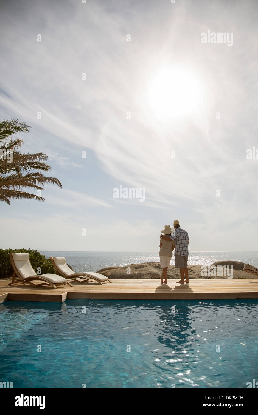 Vieux couple hugging by pool Banque D'Images