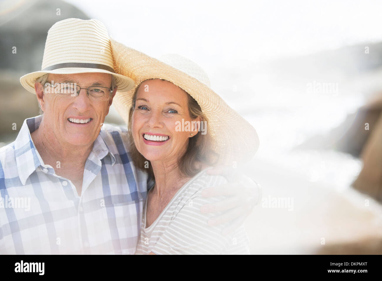 Older couple smiling on beach Banque D'Images