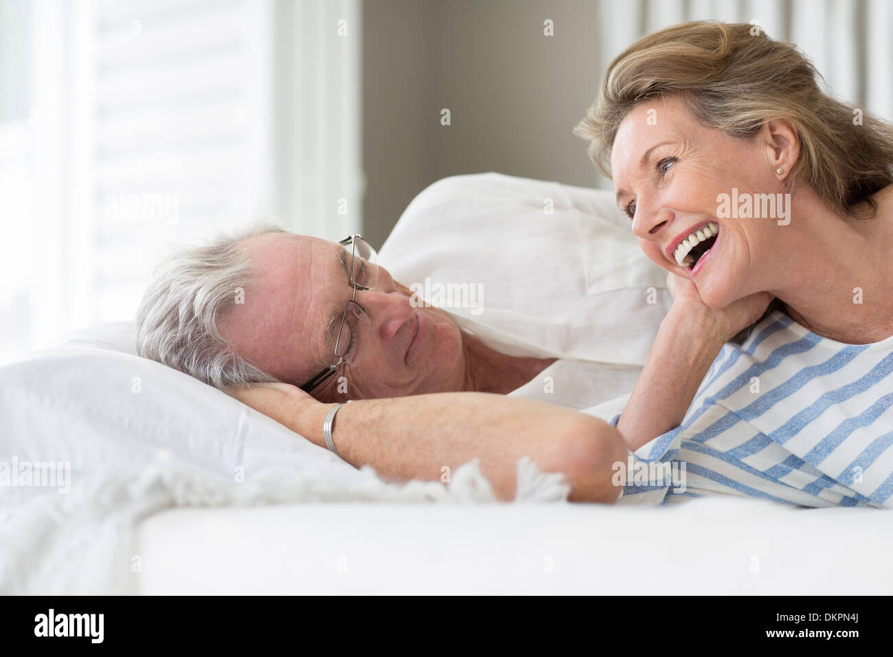 Vieux couple relaxing on bed Banque D'Images