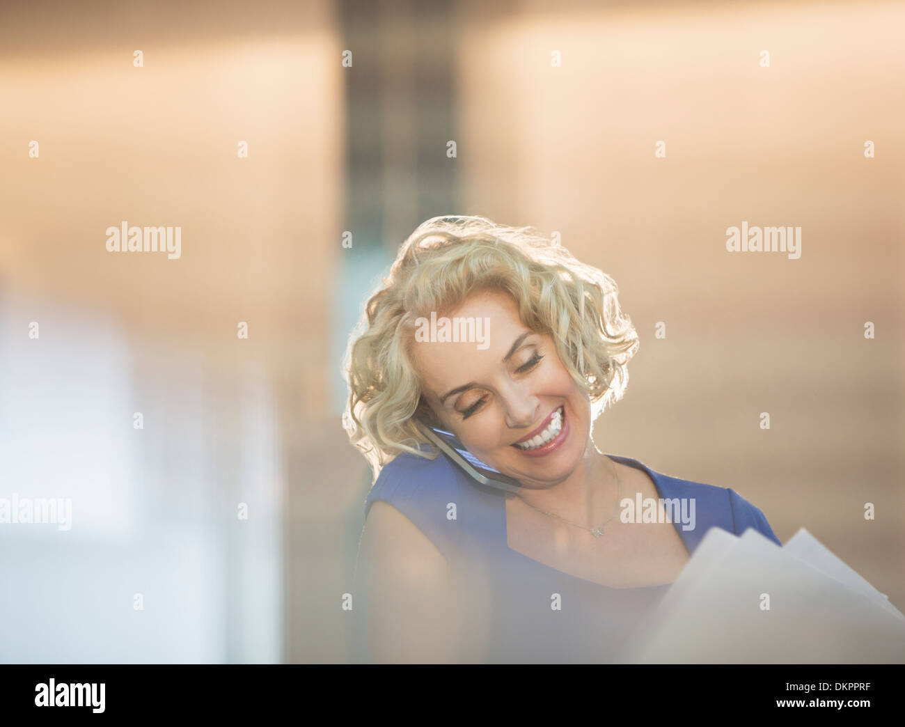 Businesswoman talking on cell phone in office Banque D'Images