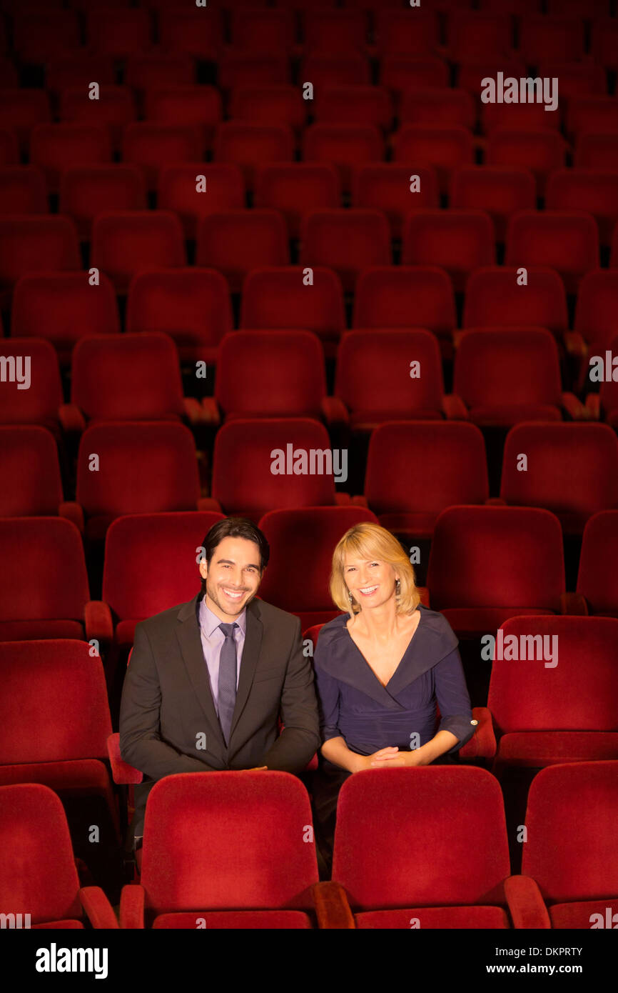 Portrait of smiling couple sitting in empty Theatre Banque D'Images