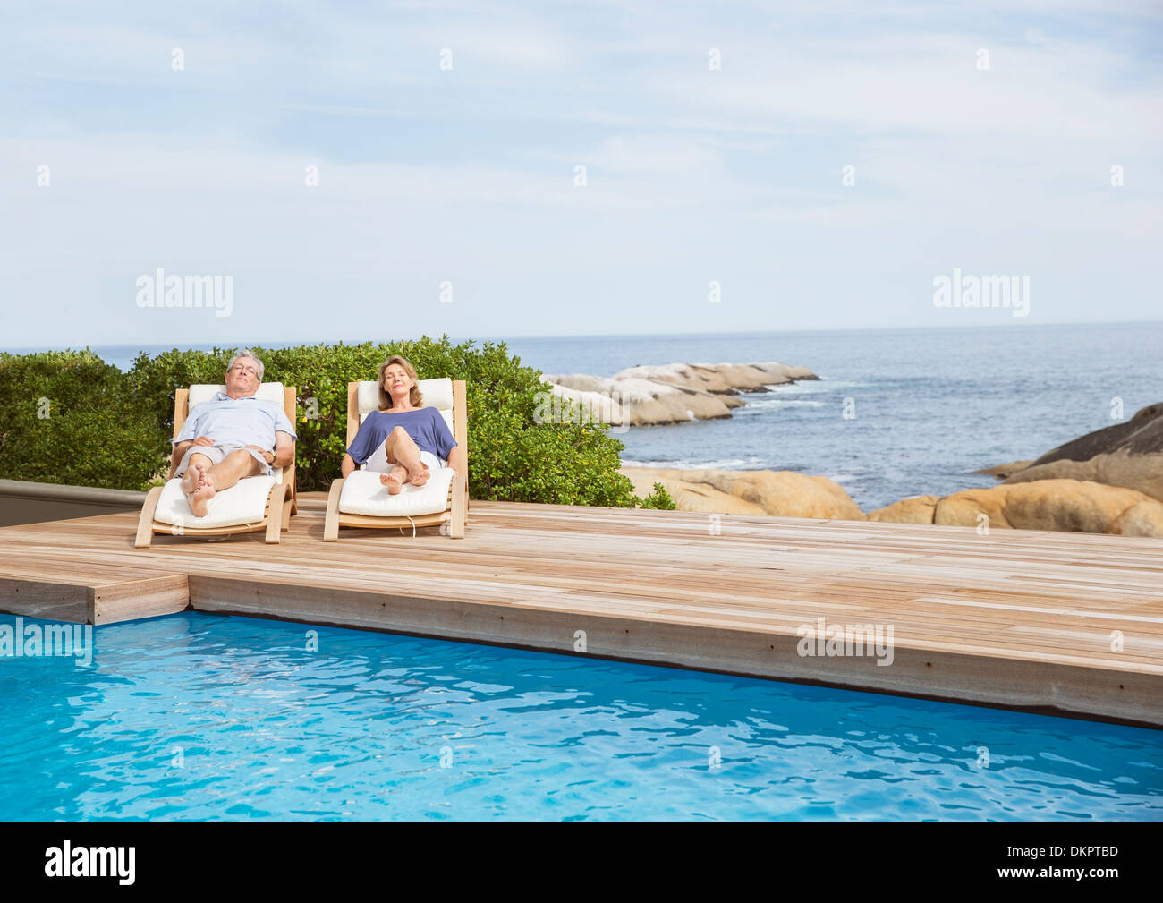 Senior couple relaxing at poolside Banque D'Images