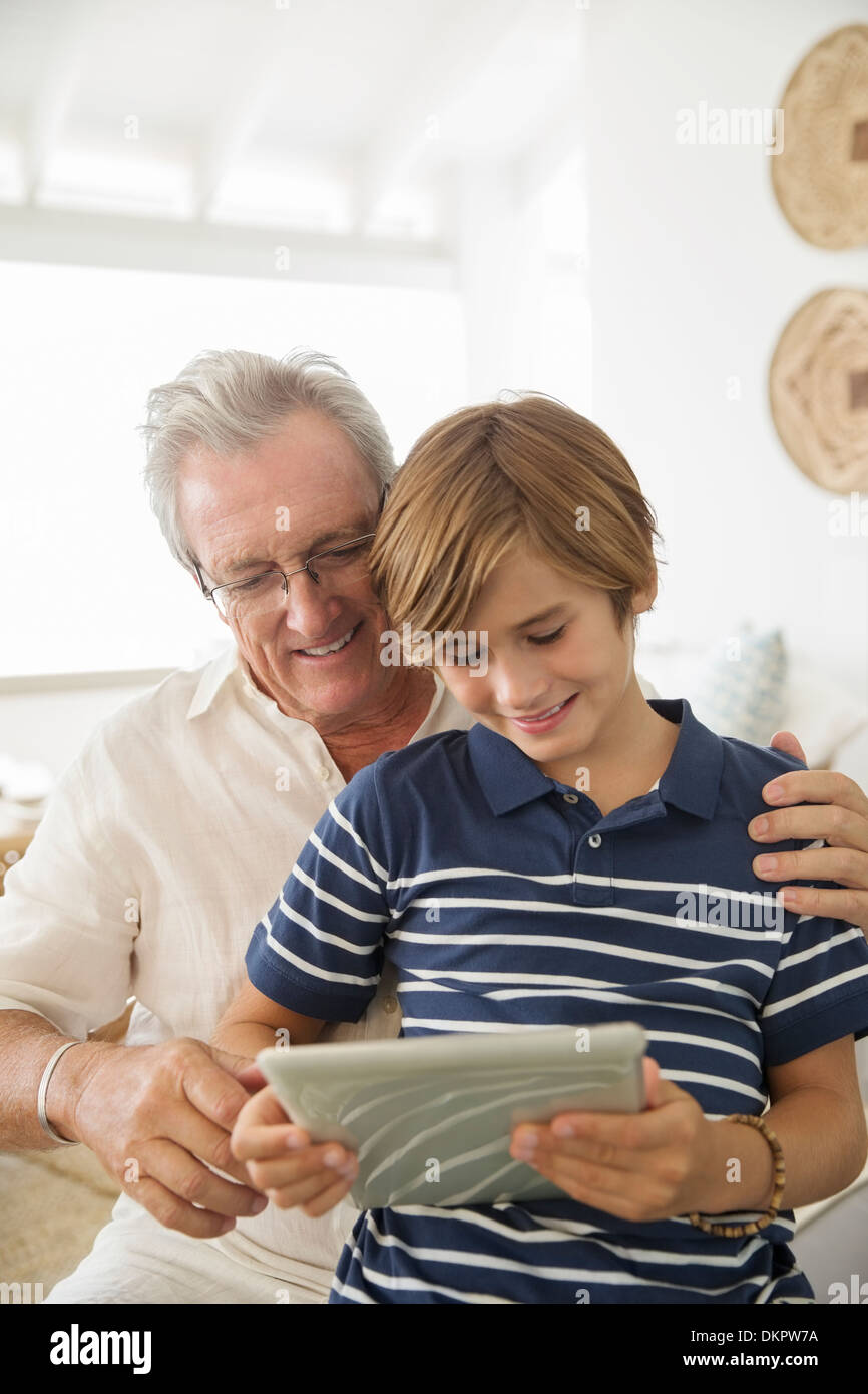 Vieil homme et son petit-fils using digital tablet Banque D'Images