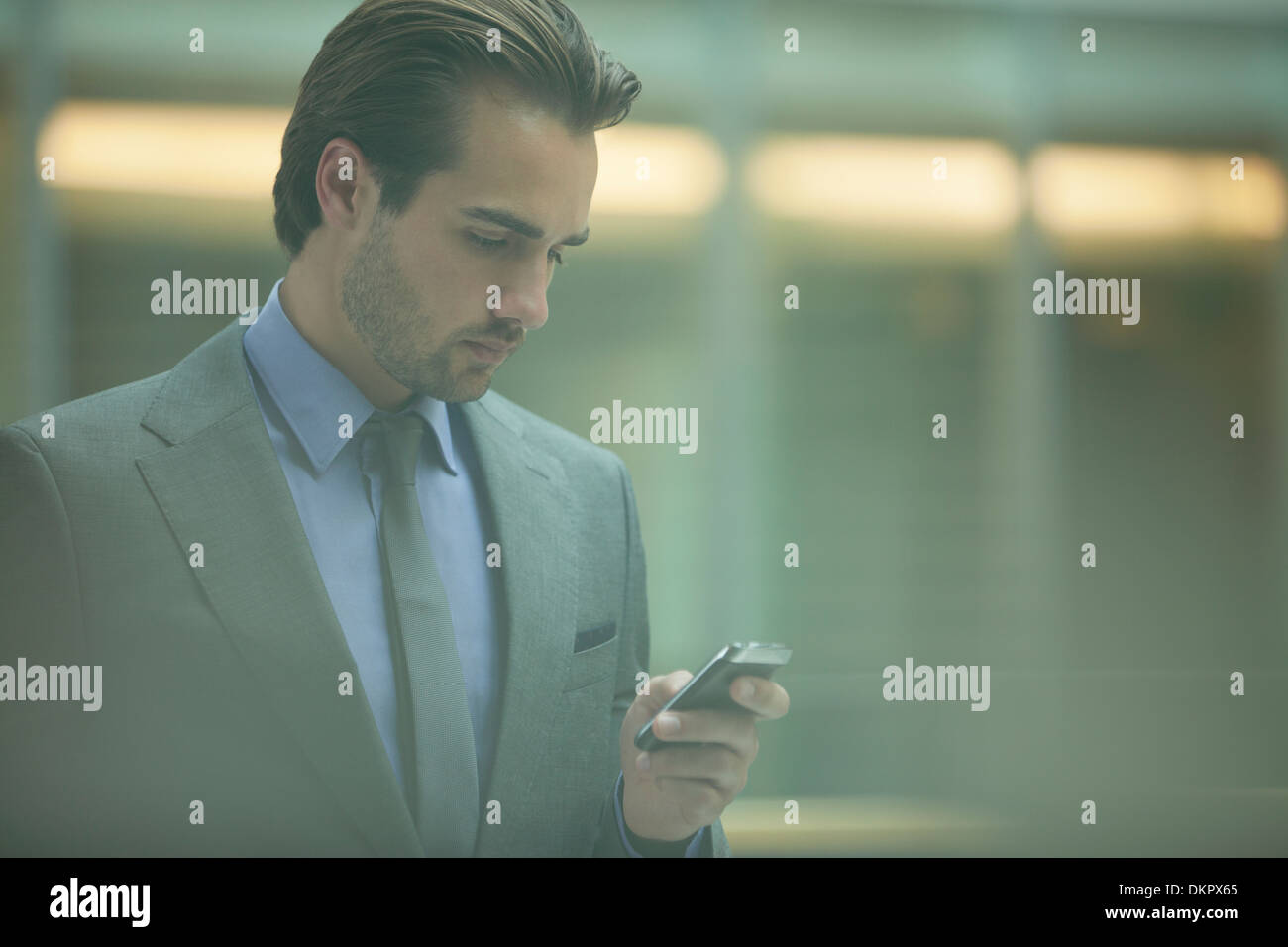 Businessman using cell phone in office Banque D'Images