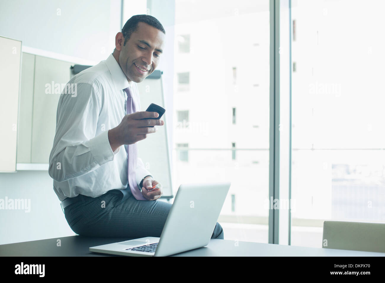 Businessman using cell phone in office Banque D'Images