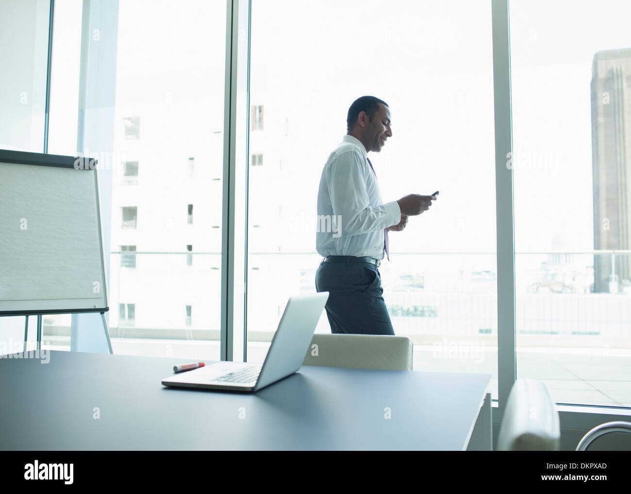 Businessman using cell phone in office Banque D'Images